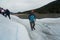 A mountain guide helps ice trekking tourists on Perito Moreno Glacier in the Los Glaciares National Park