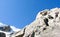 Mountain guide looking up on a rocky climb in the French Alps with rope teams ahead of him