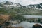 Mountain highlands lake lanscape with snowy hills and water reflection