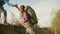 Mountain hiker man and woman climbing a steep hill.