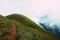 Mountain hill with grass field with sea of fog or white clouds at `Doi MonJong` Chiangmai, Thailand