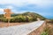 Mountain hill rural roadway with wood signboard