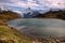 Mountain lake with clouds and white mountains peaks