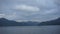 Mountain lake on dusk with fishing boats in the distance