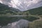 mountain lake panorama view in late summer in Slovakian Carpathian Tatra with reflections of rocky hills in water. Rohacske plesa