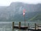 Mountain lake with small wooden jetty, pier mole, wind sleeve. Alpine massif, beautiful canyon in Austria.