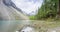 Mountain lake timelapse at the summer or autumn time. Wild nature and rural mount valley. Green forest of pine trees and