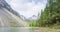 Mountain lake timelapse at the summer or autumn time. Wild nature and rural mount valley. Green forest of pine trees and