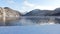 Mountain lake in winter. Snowy shore, open non-freezing water, mountain peaks