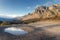 Mountain landscape with blue sky reflection in puddle at sunset