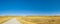 Mountain landscape. Country road in a harvested autumn field