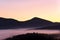 Mountain landscape at dawn. Majestic mountains covered with coniferous trees and fog.