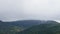 Mountain landscape in early foggy morning. Pine trees forest with hills in fog, time lapse shot