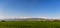 Mountain landscape. Fresh green meadows at sunrise in springtime, mountains lit by the rising sun