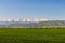 Mountain landscape. Fresh green meadows at sunrise in springtime, mountains lit by the rising sun