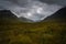 Mountain landscape in Glen Coe with dark clouds hanging over the peaks, Highland, Scotland