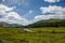 Mountain landscape in the Glencoe area in Scotland, Springtime view mountains with grassland and countryside road in the valley of