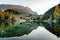 Mountain landscape and lake with fall color reflections and yellow larch trees