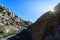 Mountain landscape with large granite rocks, blue sky and sun on the horizon with sun flare and desert atmosphere. Valdemanco,