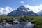 A mountain landscape with a peak and a stream