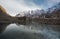 Mountain landscape with reflection on the water. Stone hut stand alone at Karakoram range in Pakistan