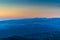 Mountain landscape with several rows of hills at sunset.