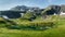 mountain landscape with small glacial lake . Mountain peaks with snow, green grass in the foreground