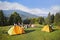 Mountain landscape at sunshine. Tourist tents in forest