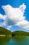 Mountain landscape with turtle shaped cloud over the lake Gozna surrounded by forest at Valiug