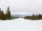 Mountain landscape. View from the mountain: snow, forest, rope t