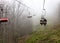 Mountain lift carries tourists to the misty mountain