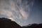 Mountain with little snow on the top and moving cloud in the blue color night with stars in winter at Lachung in North Sikkim.