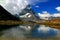 A mountain Matterhorn view partially covered by clouds and reflected in the smooth surface of the lake, in Switzerland