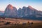 Mountain meadow and house Alpe di Siusi or Seiser Alm in the background Langkofel mountain range at sunset with Province of