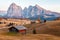 Mountain meadow and house Alpe di Siusi or Seiser Alm in the background Langkofel mountain range at sunset with Province of