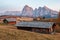 Mountain meadow and house Alpe di Siusi or Seiser Alm in the background Langkofel mountain range at sunset with Province of