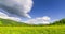 Mountain meadow time-lapse at the summer or autumn time. Wild nature and rural field. Clouds movement, green grass and