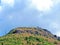 A mountain in Montenegro with a church on top, on a summer sunny day, clouds. Rock granite view from below the summit