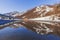 The mountain near the road is reflected in the spring puddle of