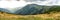 Mountain panorama in the cloudy day. Beautiful natural panoramic landscape in the summer time. Beautiful panorama for a postcard