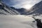 Mountain panorama with snow, small river and sun in winter in Stubai Alps