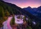 The mountain pass of Maloja, Switzerland. A road with many curves among the forest. A blur of car lights. Landscape in evening tim