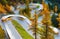 The mountain pass of Maloja, Switzerland. A road with many curves among the forest. Blurred lights of a bus. Landscape in autumn t
