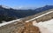 Mountain pathway on slope among stomes and snow