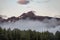 Mountain peak and cloudy forest at sunset time in Alaska National Park.