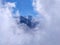 Mountain peak peeking from clouds. Cloud clearing exposing epic Indian Himalayas Mountain peaks. Mountain peaks through clouds.