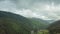 Mountain peaks and morning sky with smooth moving clouds. Summer landscape paeceful valley trees in the meadow at