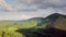 Mountain peaks and morning sky with smooth moving clouds. Summer landscape paeceful valley trees in the meadow at