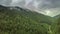 Mountain peaks and morning sky with smooth moving clouds. Summer landscape paeceful valley trees in the meadow at