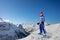 Mountain peaks panorama and girl with ski on top